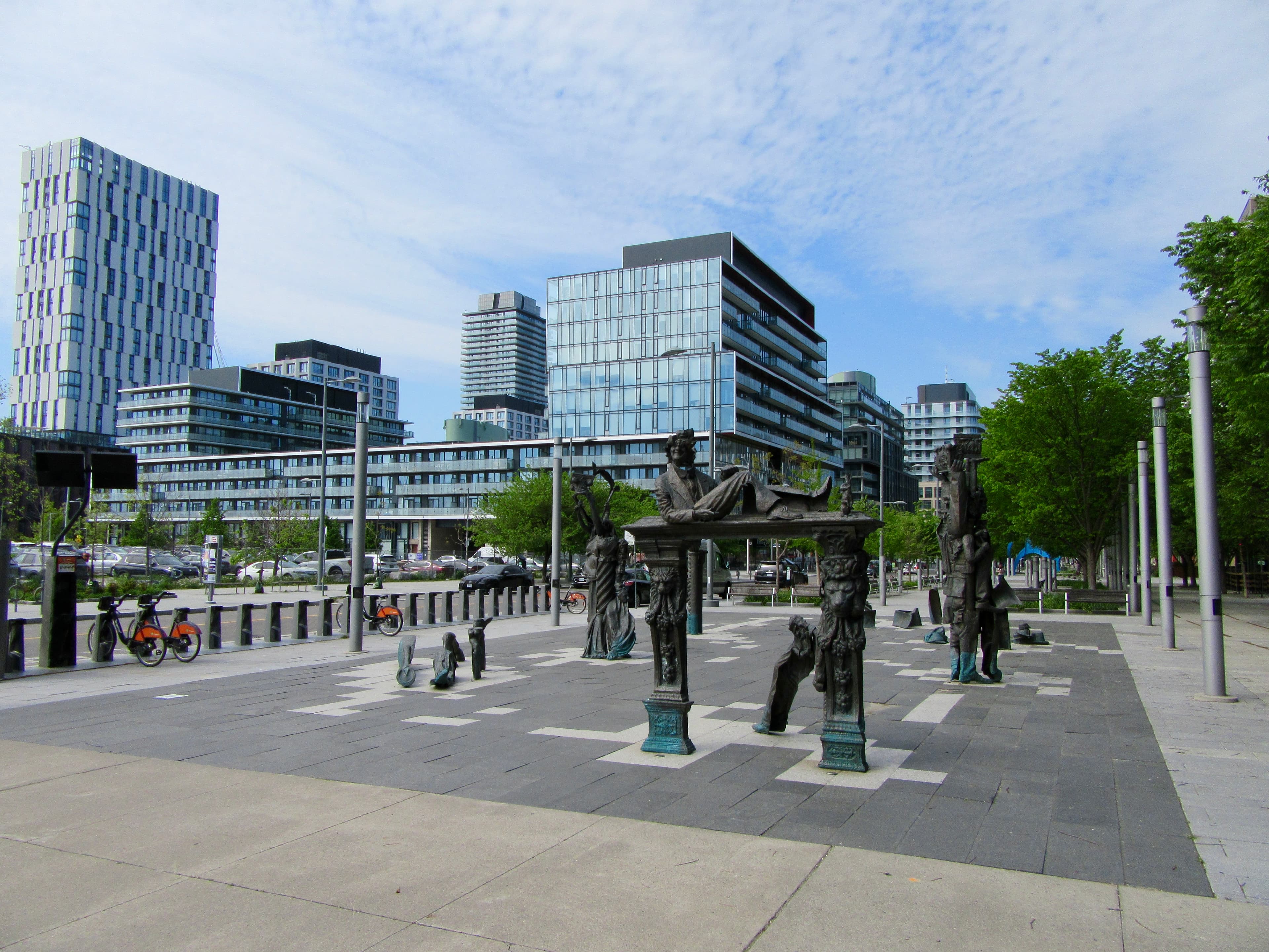Toronto's waterfront and downtown skyline framed by sculpture and a public plaza
