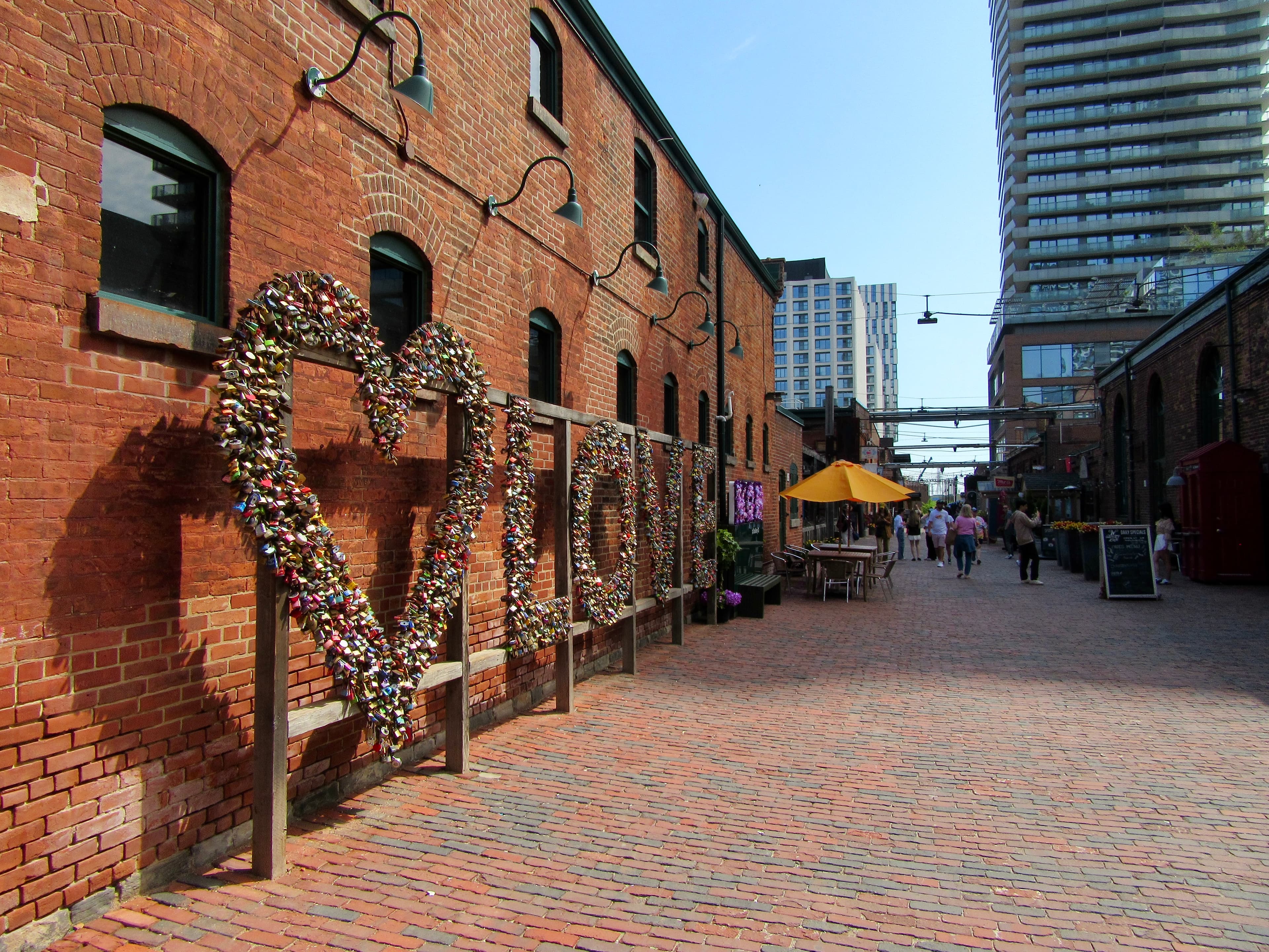 The 'Toronto' love-locks sign in the Distillery District, set against a heritage brick warehouse